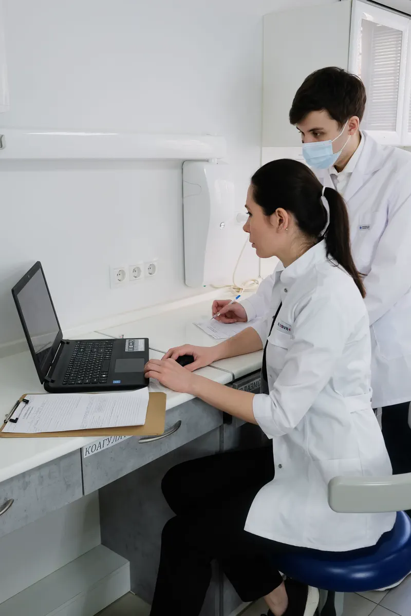 Une médecin travaille sur un ordinateur portable.